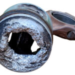 Gezeigt wird ein Aluminium-Kolben, dessen Kolbenboden ein großes Loch aufweist.