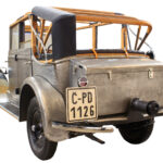 Das Foto ist von hinten links aufgenommen, der Pkw ist erst teilweise restauriert. Auf dem einen Kotflügel sind zur Veranschaulichung 5 Lackschichten nebeneinander sichtbar.