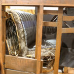 Fotografiert wurde die nur zum Teil restaurierte Sitzbank, so dass die inneren Federn und Stoffe sichtbar werden.