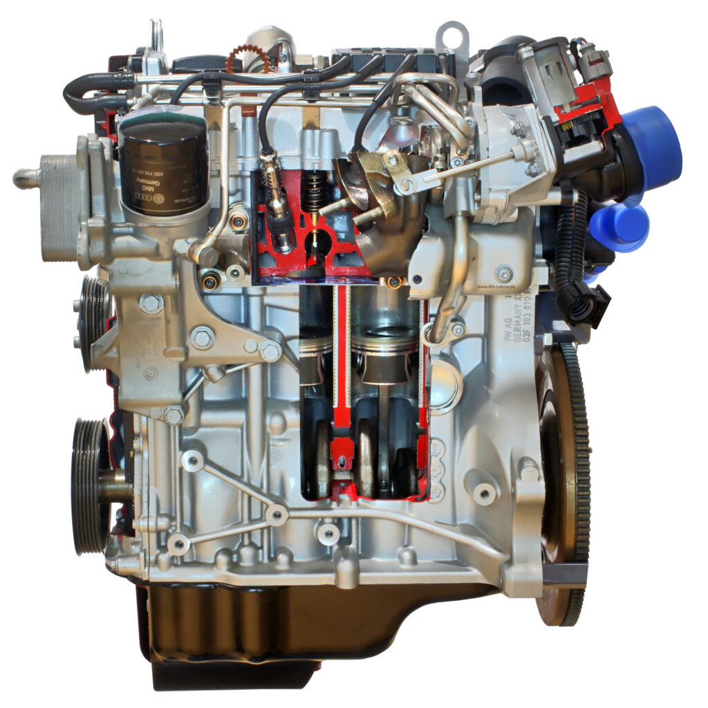 Fotografiert ist der Reihenmotor EA111 von der Seite. Der Motor ist ein Schnittmodell, so dass die Kolben und die Pleuel im Motorblock sichtbar sind.