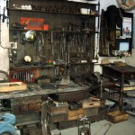 Blick in eine alte Zweiradwerkstatt mit Werkbank, Werkzeug und Ersatzteilen