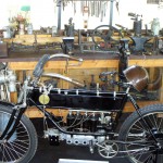 Blick in eine alte Zweiradwerkstatt mit einer besonderen Motorradkonstruktion im Vordergrund
